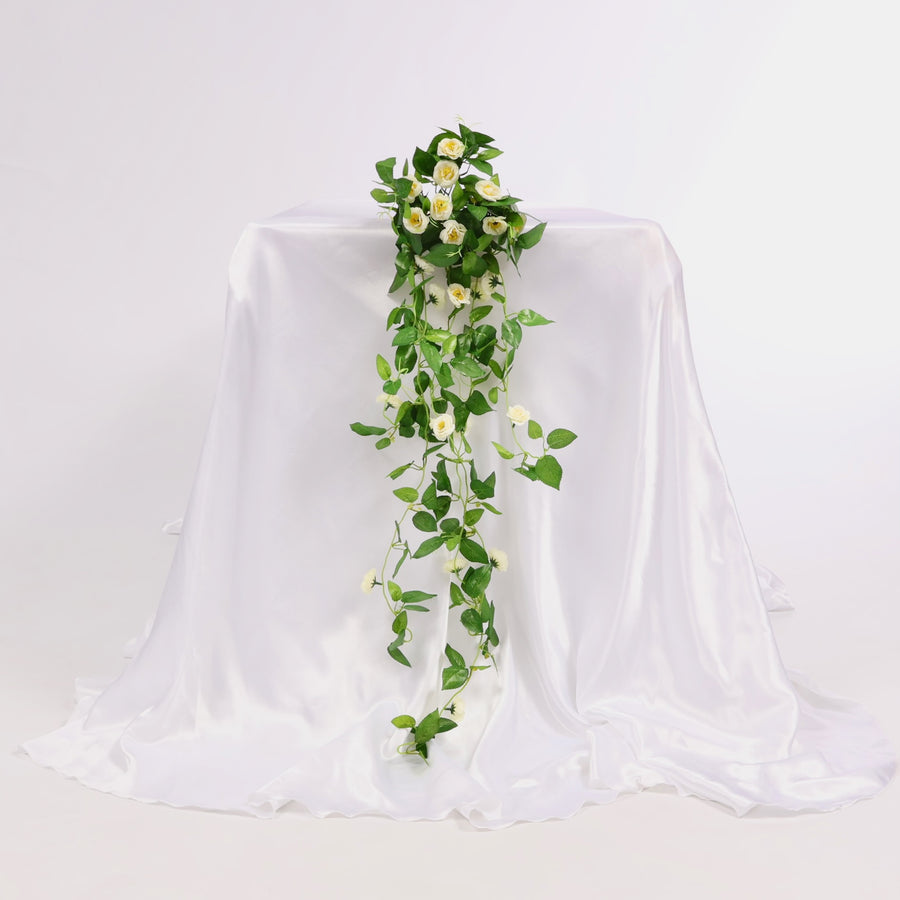 Artificial flower bouquet on a draped white fabric background