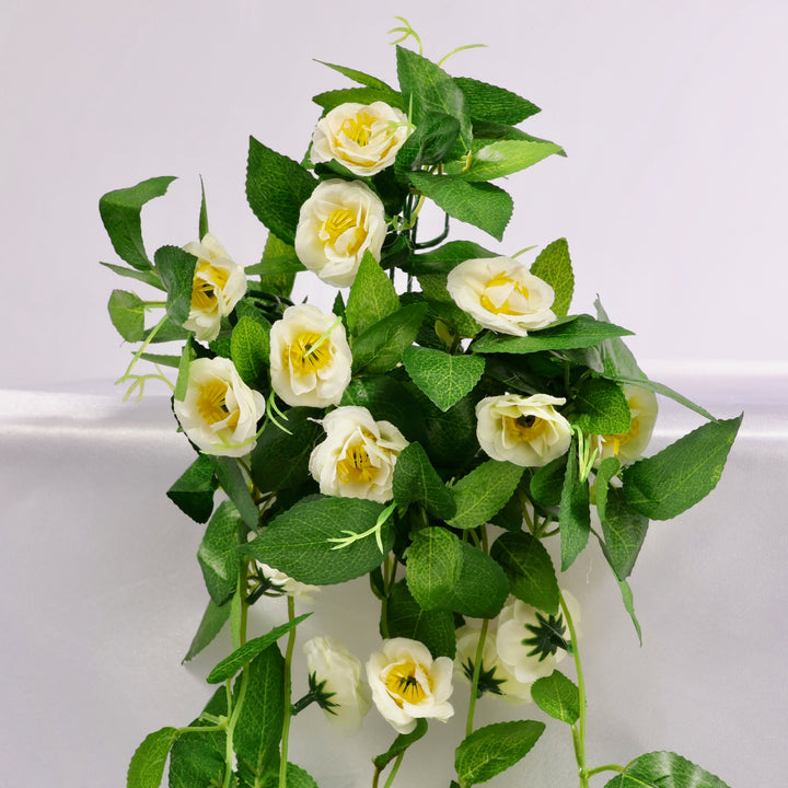 Artificial flower vine with white roses on a white background