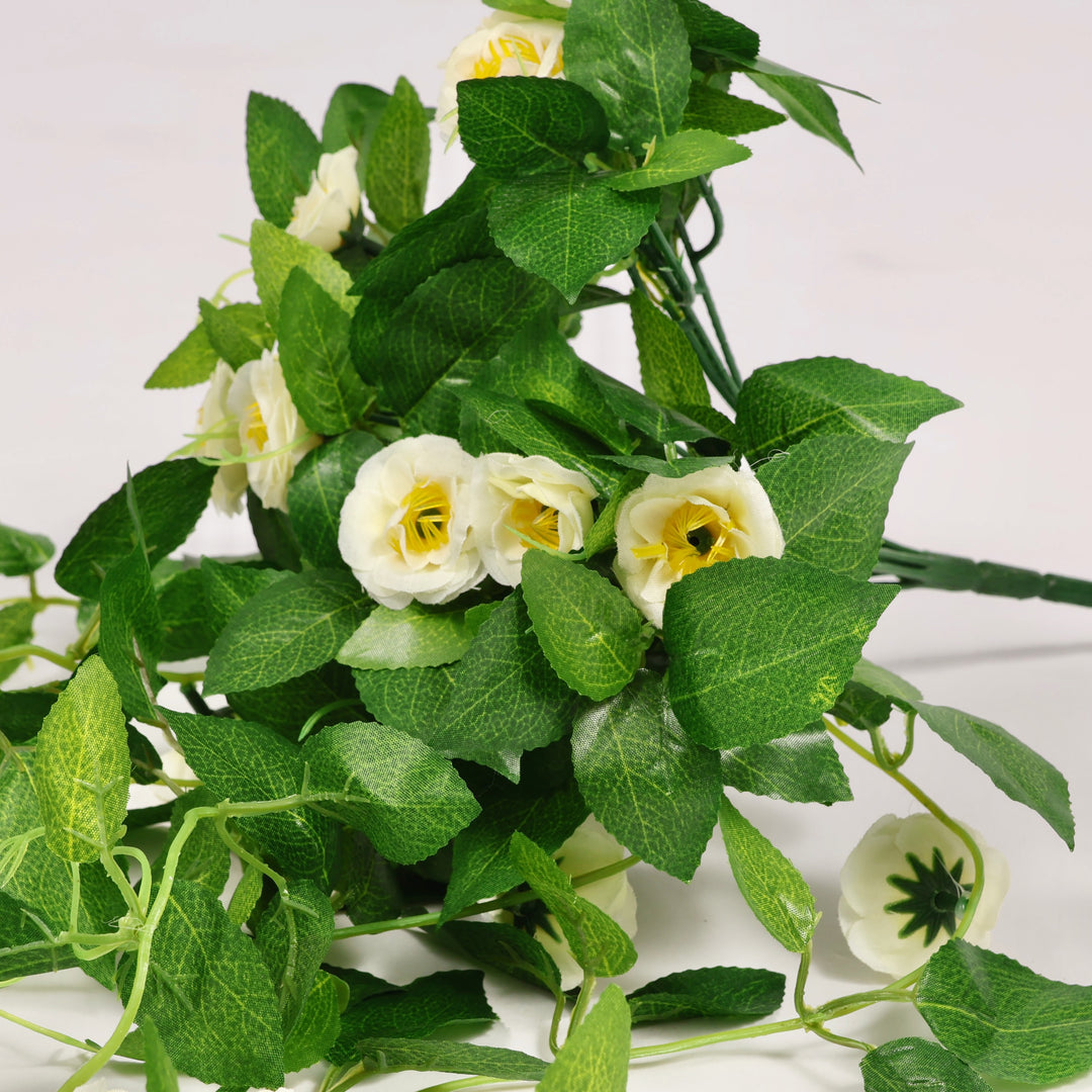 Bouquet of artificial green leaves and white flowers on a white background