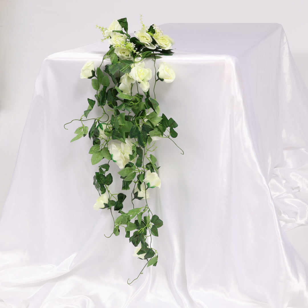 Artificial green vine bouquet with white flowers on a white background