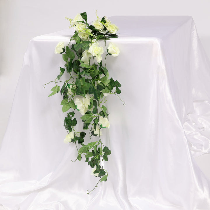 Artificial green vine bouquet with white flowers on a white background