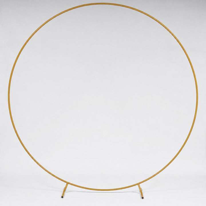 A gold metal circular stand photographed against a seamless white studio background.