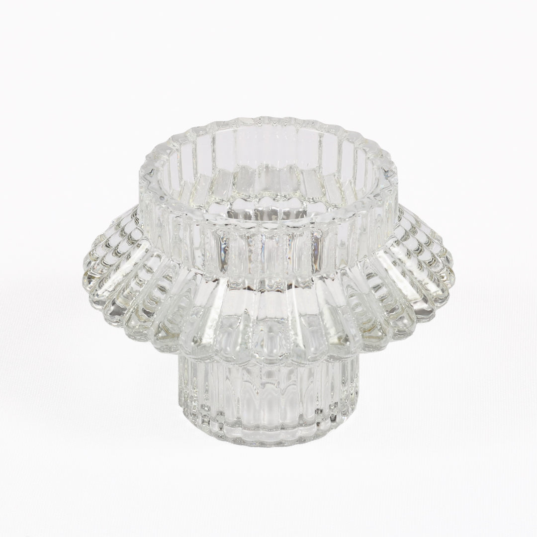 Clear glass candle holder with a layered design on a white background
