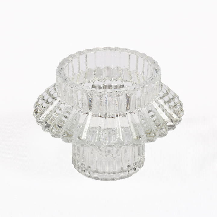 Clear glass candle holder with a layered design on a white background