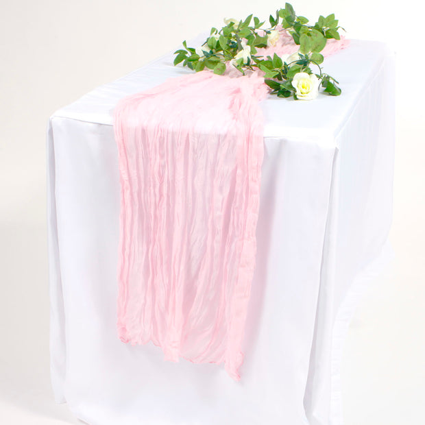 Light Pink Cheesecloth table runner on white tablecloth with white rose vine