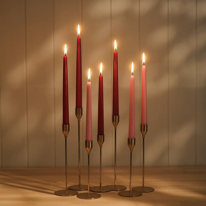 Ambient shot with soft shadows of mixed taper candle holders with lit Pink and Burgundy taper candles 