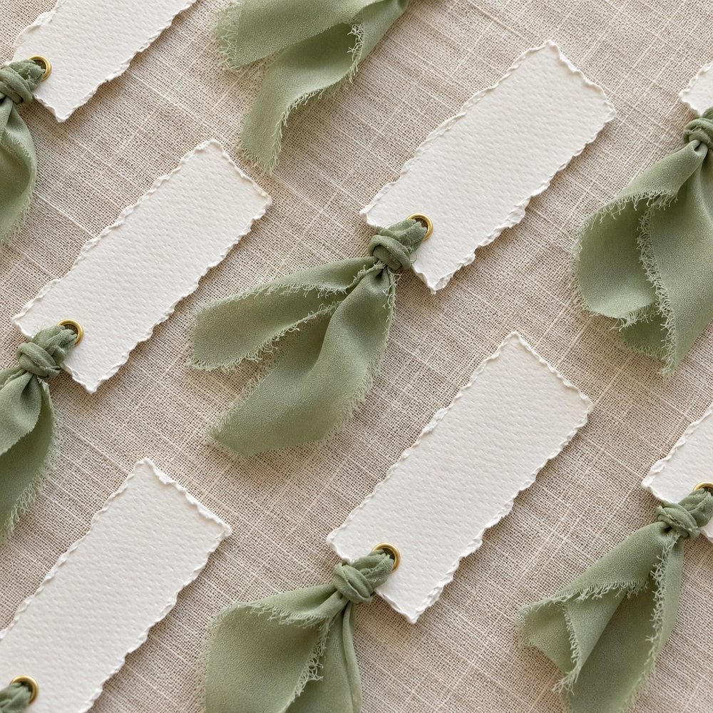 Sage Ribbon Tied onto Paper Tags on Linen Tablecloth 