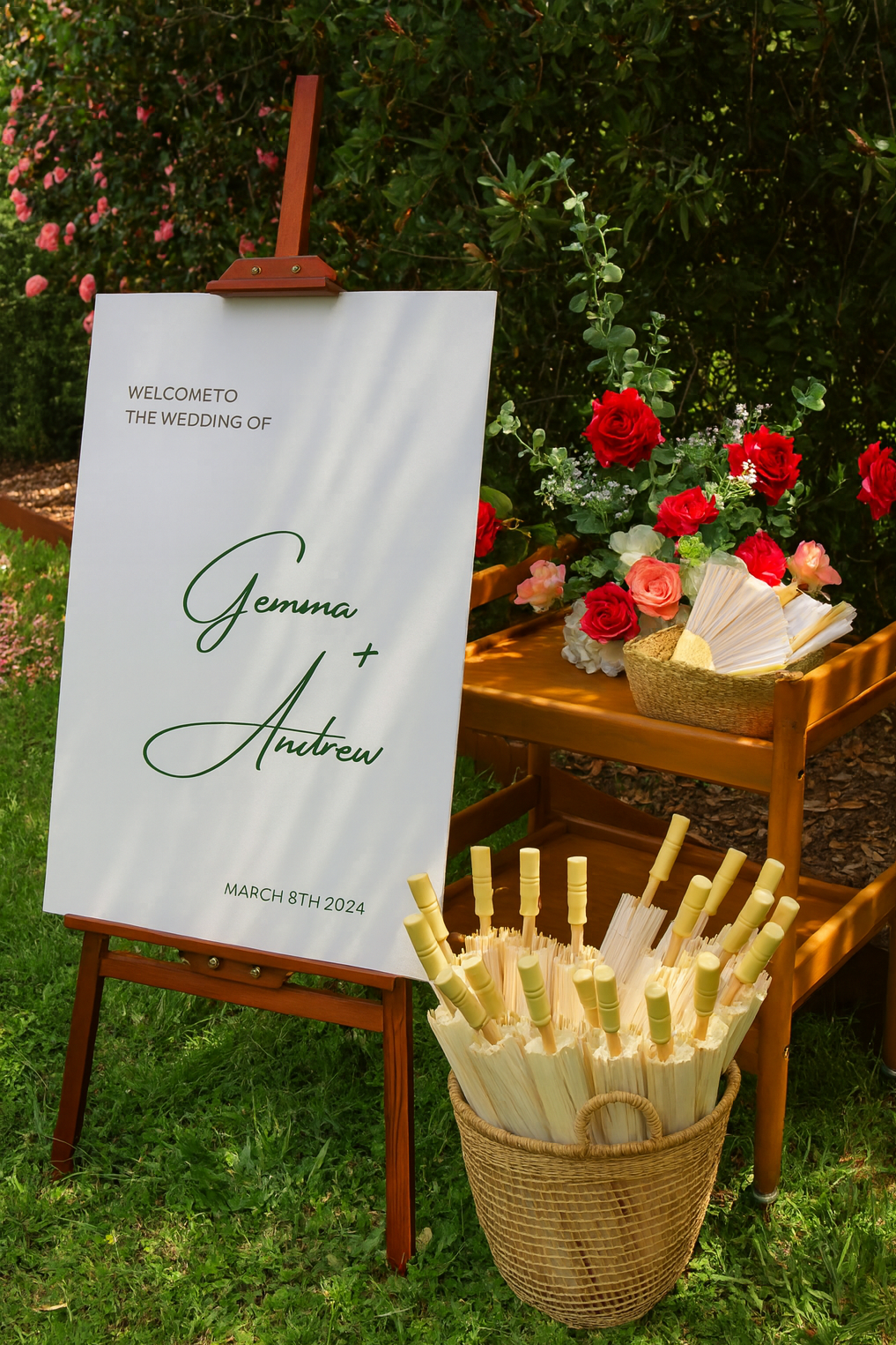 Wooden easel welcome sign with paper parasols and hand fans
