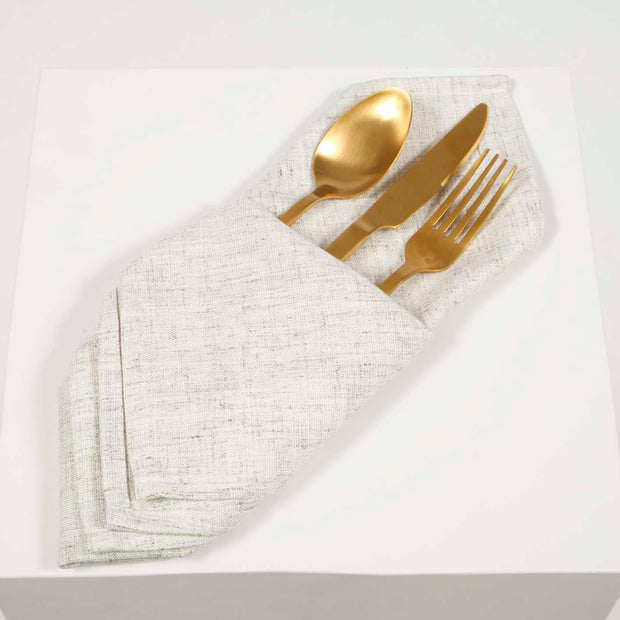 Ivory linen napkin folded with gold cutlery