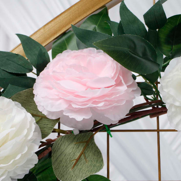 close up of large pink rose flower on garland with green leaves.